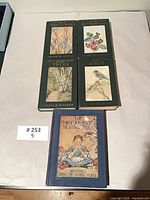 Five hardcover books arranged face up showing covers and titles