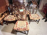 Six wooden dining chairs grouped together showing design and upholstery