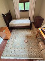 Full view of rug under bed showing overall pattern and fringe