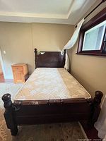 Full view of bed frame with mattress and nearby nightstand