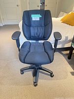 Front angled view of black cushioned swivel chair showing full structure