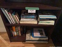 Two-shelf grouping of gardening books, top shelf shows vertical row and horizontal stack