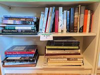 Overall view of two-shelf lot showing vertical and horizontal stacks of books