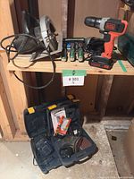 Shelf with circular saw, cordless drill, screwdrivers, open case below