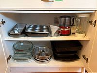 Entire cabinet shelf showing appliances and bakeware
