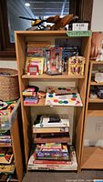 Front view of bookshelf loaded with various items, showing three adjustable shelves and overall form
