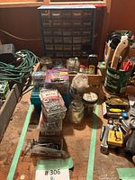Workbench area showing all items inside green tape: parts cabinet, jars, boxes, stud finder, small tools