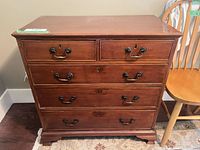 Front view showing five drawers, hardware, feet, finish