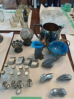 Group shot of all silver-plate, glass and cobalt lined pieces laid out on table