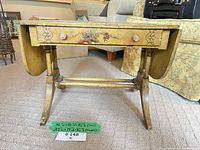 Full view of table with leaves lowered showing front drawer, legs, stretcher and painted motifs