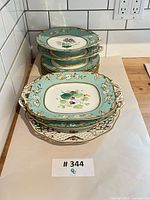Stack of round and oblong turquoise porcelain plates on counter