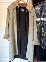 Front view of coat on hanger showing sherpa collar, cuffs, overall condition