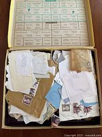 Open box filled with envelope fragments bearing postage stamps