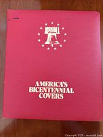 Front of red binder with Liberty Bell design and title