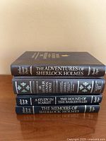 Stack of four matching Sherlock Holmes hardcovers showing spines and titles
