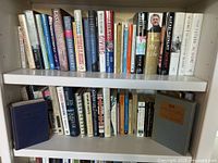 Two shelves filled with assorted hardcover and paperback books