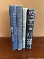 Spine view of four vintage hardcover books showing titles and authors