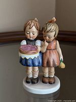 Front view of Goebel Hummel "Happy Birthday" figurine showing two girls with cake and rose