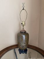 Full view of bronze lamp on wood base with harp and socket visible