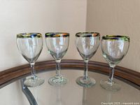 Front view of four hand-blown Mexican wine glasses on display