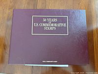 Maroon binder front cover titled "50 Years of U.S. Commemorative Stamps"