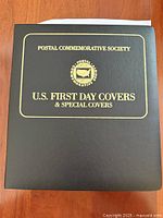 Front of black Postal Commemorative Society binder