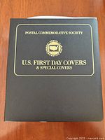 Front of black Postal Commemorative Society binder