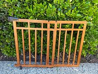 Front view of wooden adjustable gate showing slats, hardware and overall design