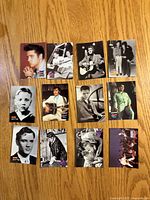Fronts of 12 Elvis Presley trading cards laid out on wood surface