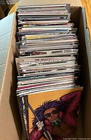Open box showing large quantity of comics stored vertically