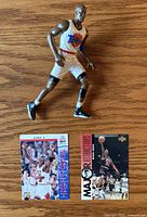 Front view of Michael Jordan action figure and fronts of two trading cards