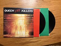 Front cover of Queen Live Killers with both LPs partially withdrawn in colored inner sleeves