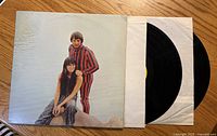 Front cover with duo photo and partial view of vinyl in sleeve