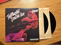 Front gatefold cover and both vinyl records partially removed from sleeves