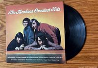 Front cover showing title and band image with vinyl partially visible