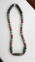 Full view of necklace showing arrangement of Dzi focal bead and various round beads