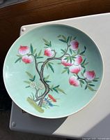 Top view showing full peach tree design on celadon plate