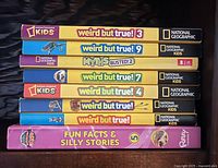 Stack of seven National Geographic Kids and Ripley fact books showing spines and titles