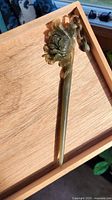 Full view of carved jade hair stick on wooden tray