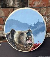 Front view of drum displaying grizzly bear painting and background scenery