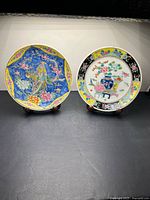 Both porcelain plates on stands, full view of designs and rims