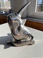 Front angled view of metal rhino head showing form and finish