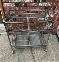 Front view of chrome wire cart showing two shelves and two mesh drawers on casters