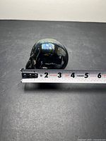 Small skull with tape measure showing length ~3 in
