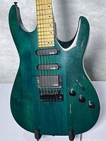 Front view displaying green finish, pickups, controls, bridge, and fretboard