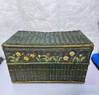 front view of green wicker basket with painted flowers