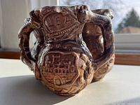 front view showing relief scene and inscription LEH on brown glazed three-chamber jug