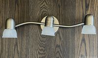 Front view of satin nickel track fixture with three alabaster glass shades