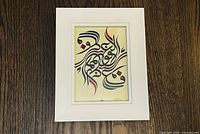 Front view of framed Arabic calligraphy artwork in white frame