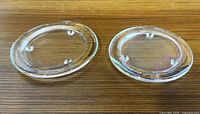Pair of clear glass footed plates side view